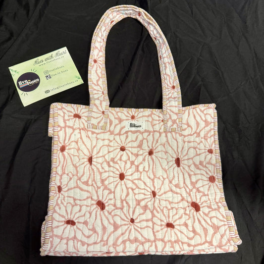 Floral patterned tote bag with a business card on a black background