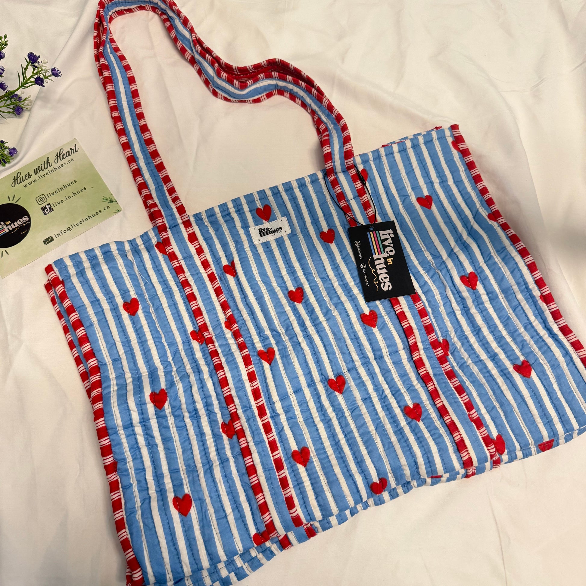 Blue and white striped bag with red hearts on a white background