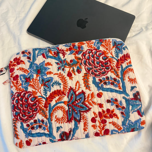 Floral-patterned pouch next to a black laptop on a white surface