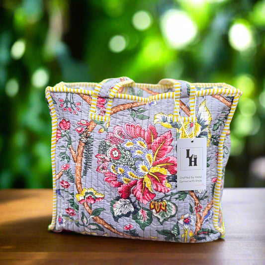 Floral embroidered bag with a visible brand label on a wooden surface outdoors.