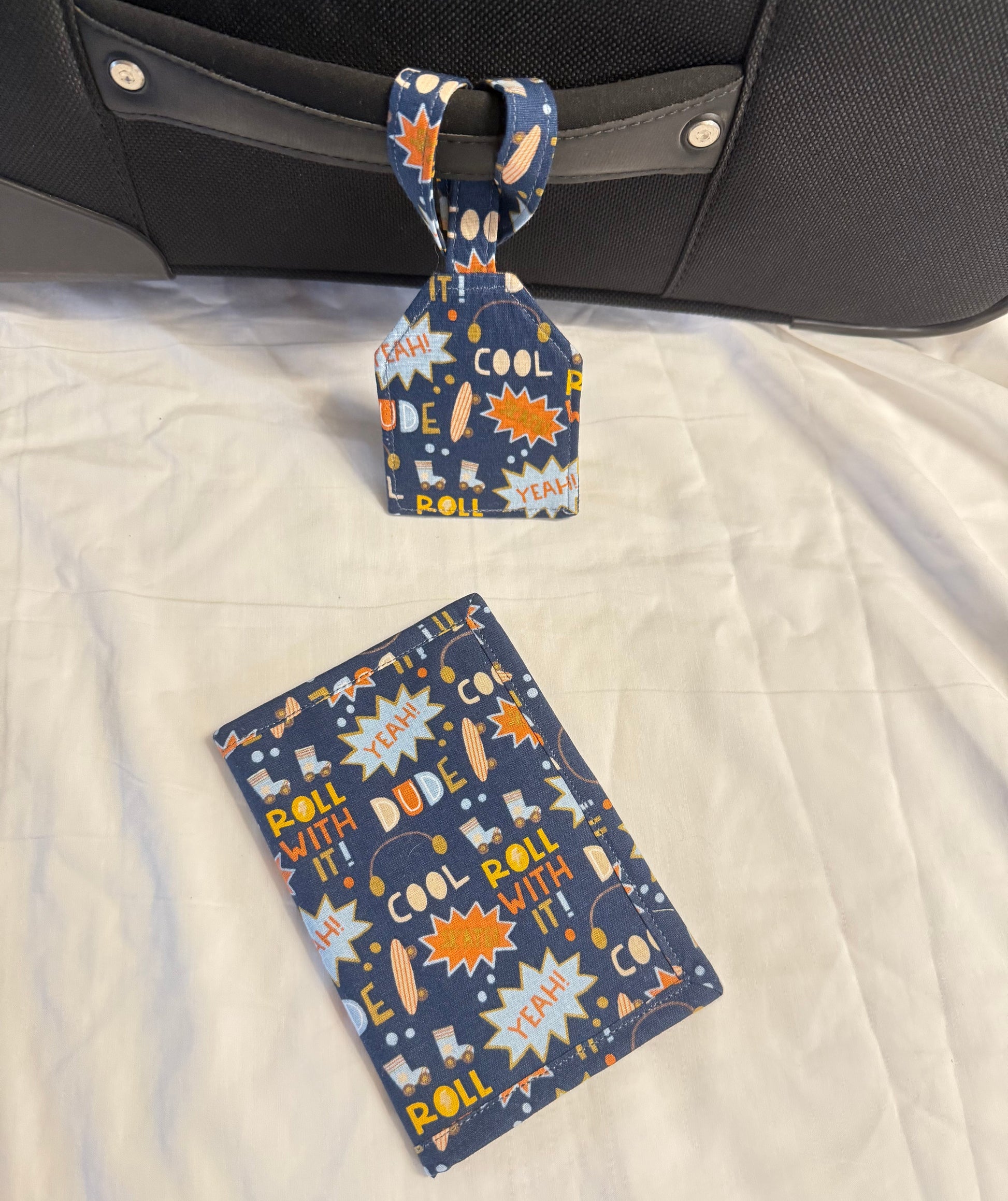 Luggage tag and card with space-themed design on a suitcase.