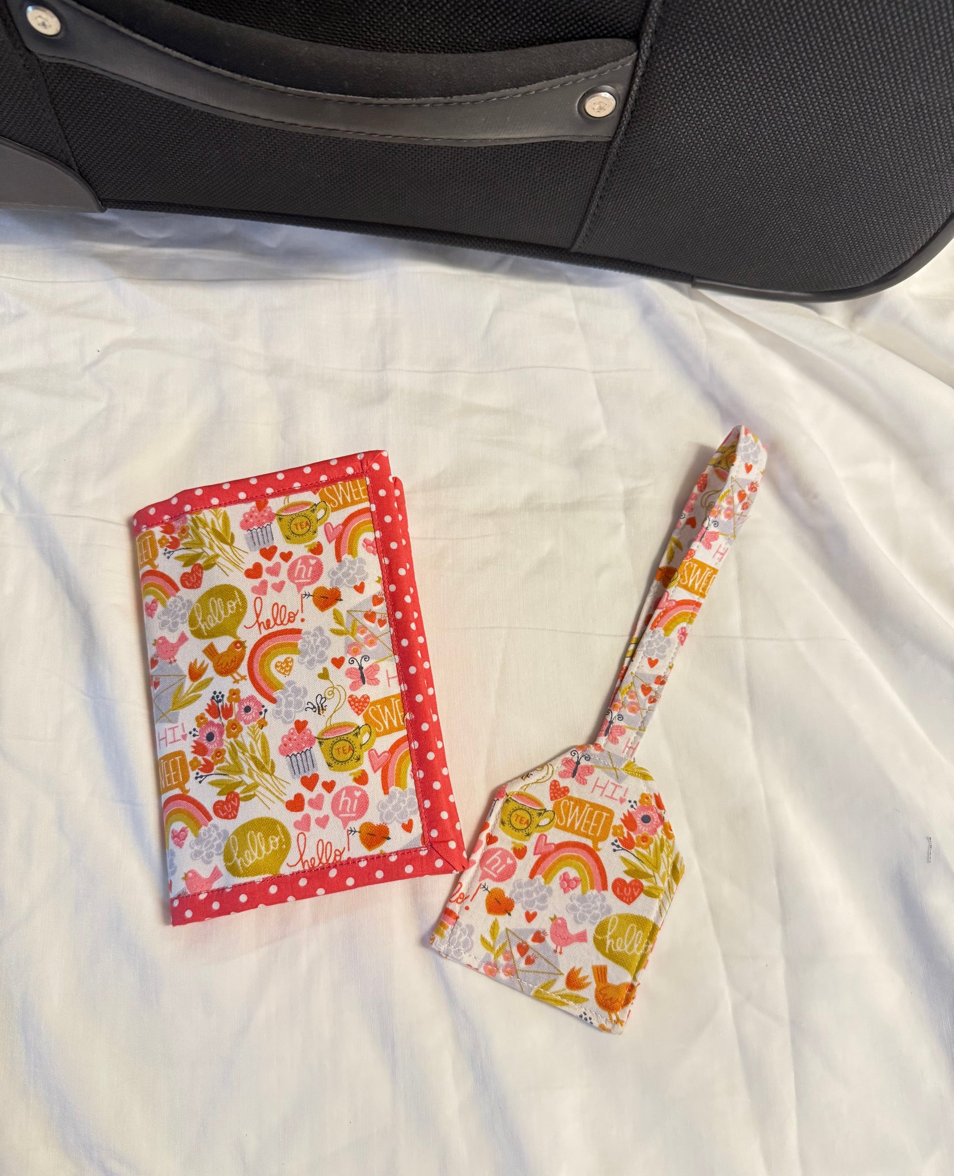 Colorful patterned headband and pouch on a white textured surface next to a black object.