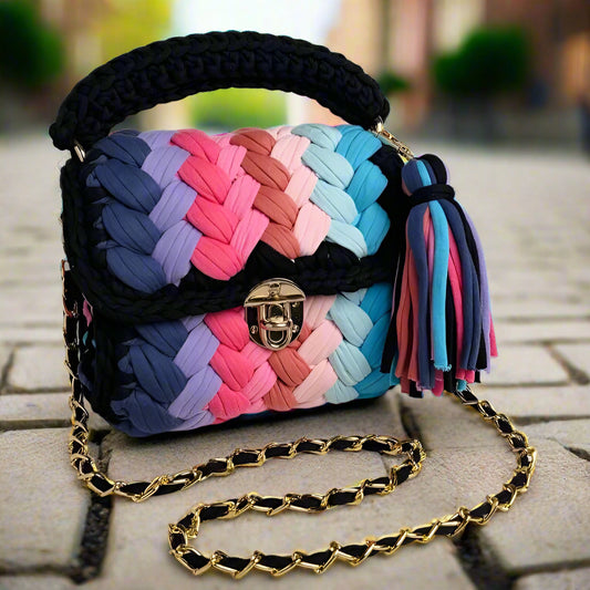 Colorful woven handbag with a tassel on a marble surface