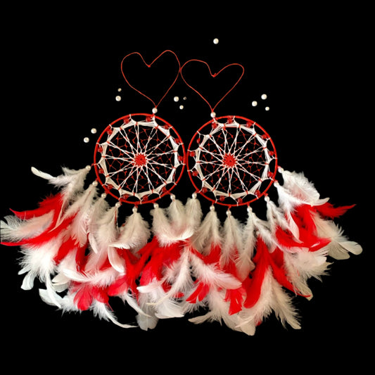 Dreamcatcher with red and white feathers on a dark background