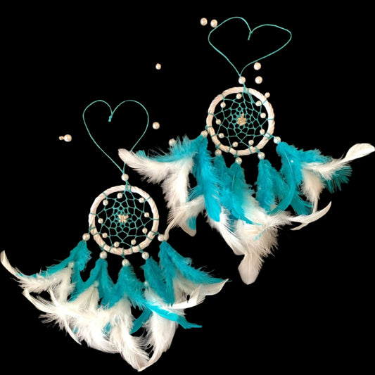 Pair of turquoise and white dreamcatcher earrings on a black background