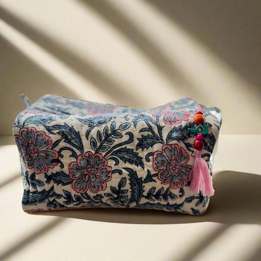 Decorative pillow with floral pattern on a couch against a floral curtain background