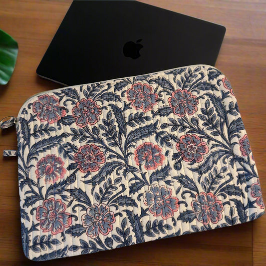 Floral patterned laptop sleeve on a white surface with a black laptop.