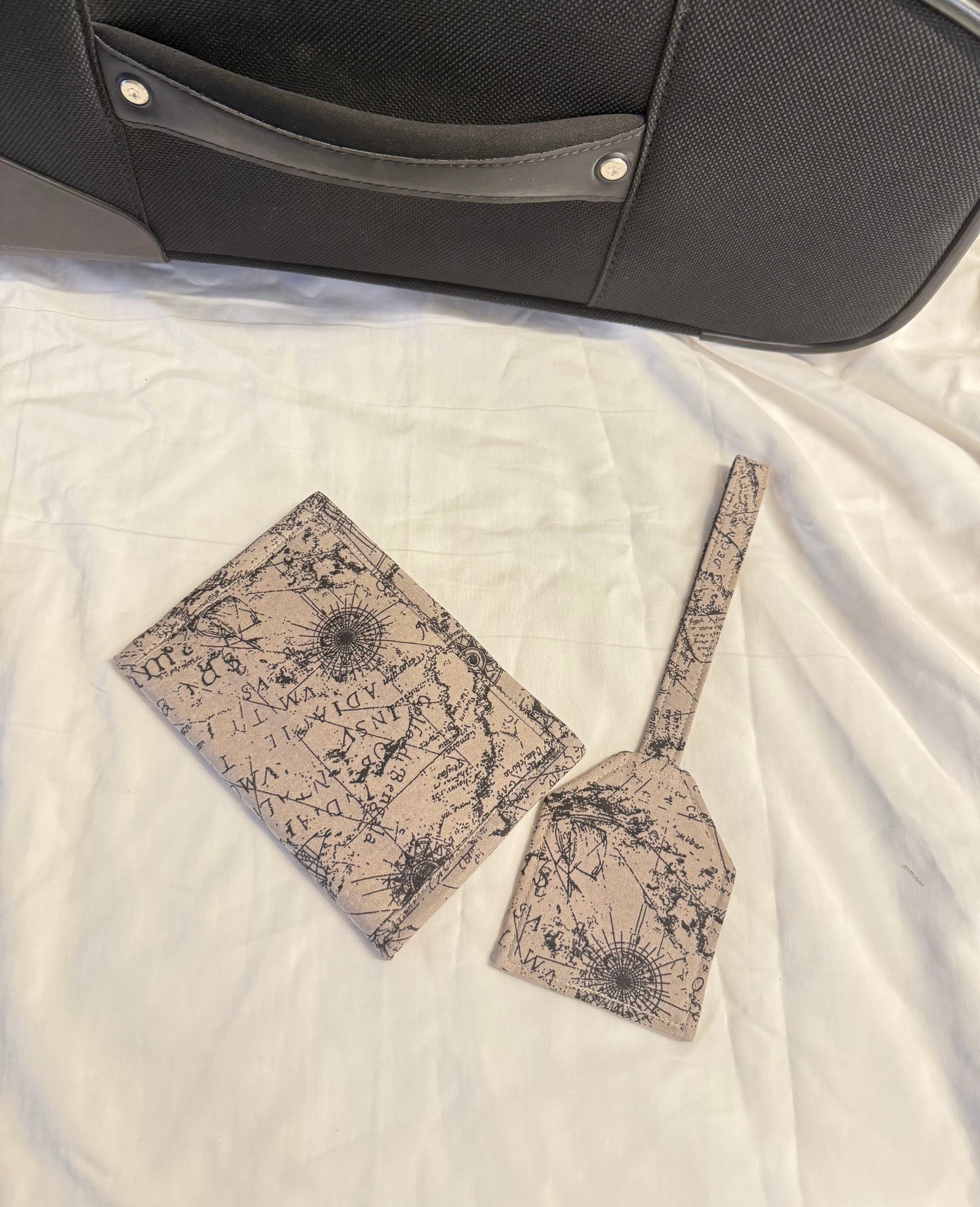 Two patterned bags on a textured surface next to a black suitcase.