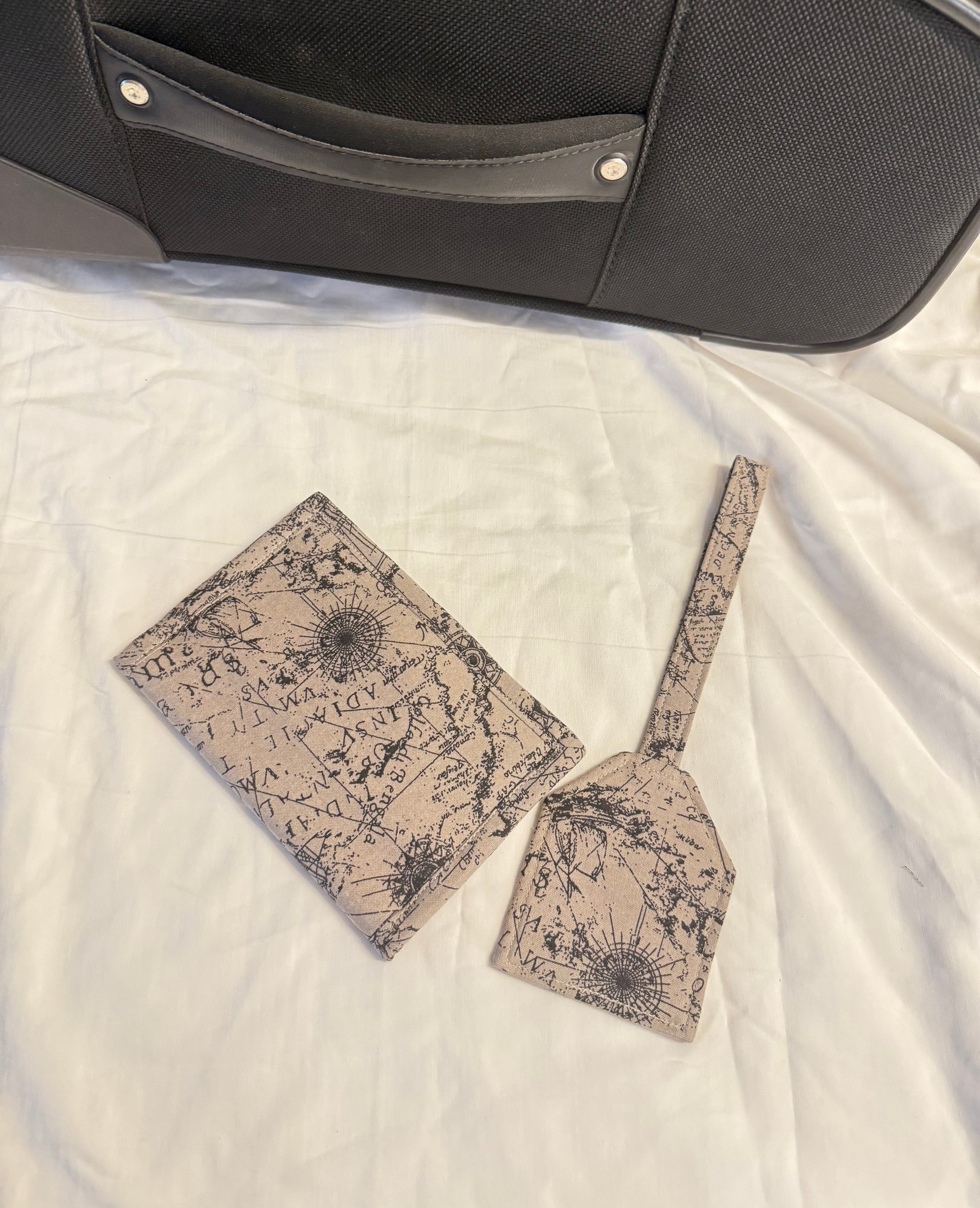 Two patterned bags on a textured surface next to a black suitcase.