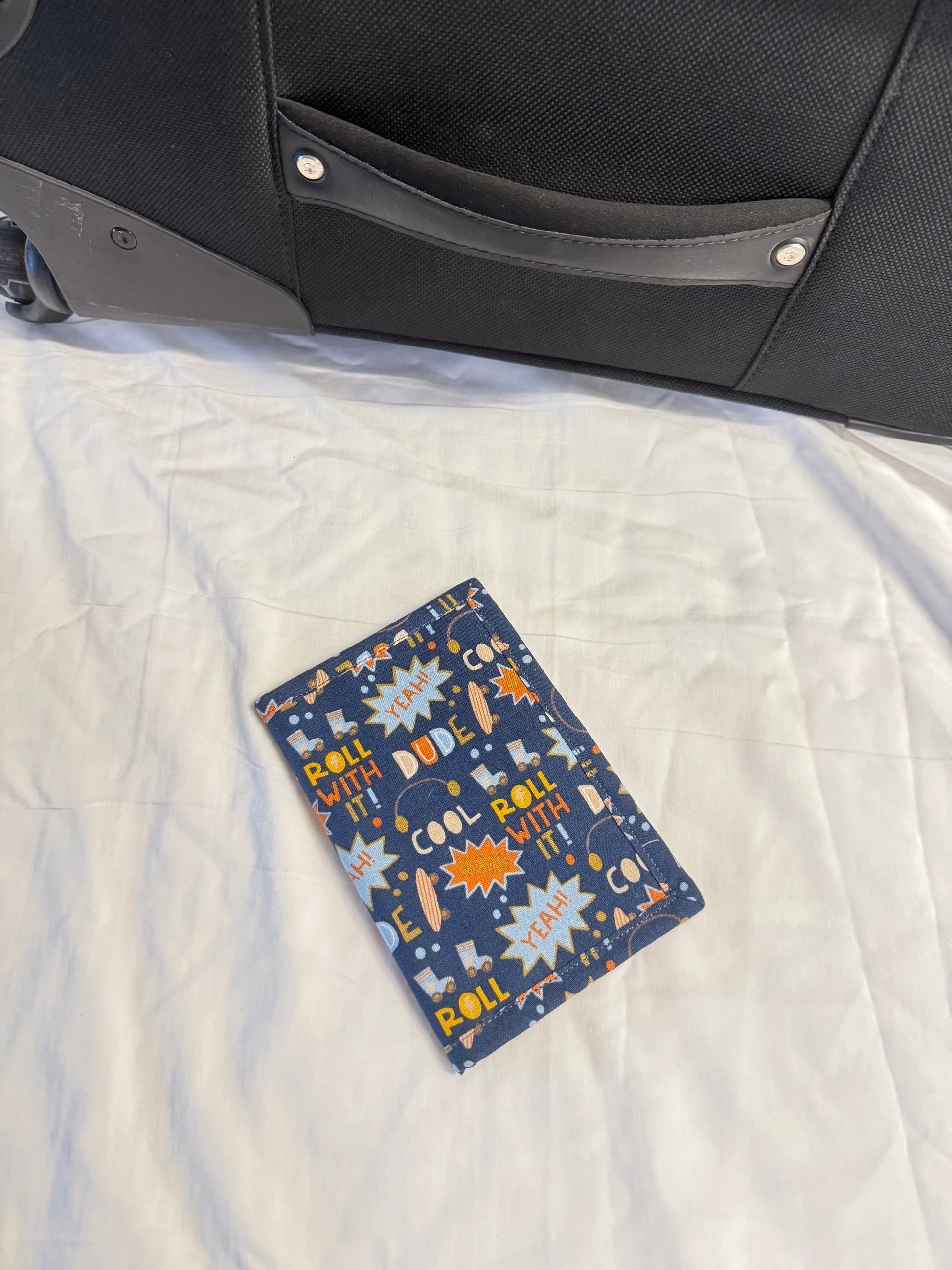 Children's book with a colorful cover featuring animals on a white quilted surface next to a black bag.