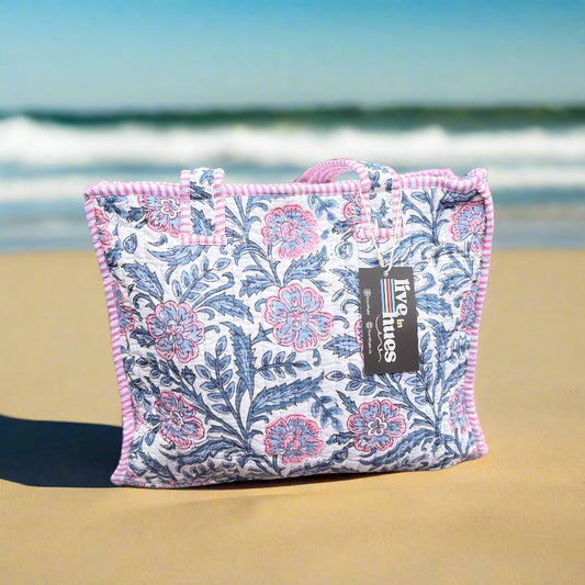 Floral-patterned bag with pink accents on a wooden bench outdoors