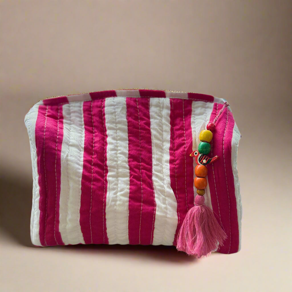 Striped pouch with colorful beads and tassel on a textured surface