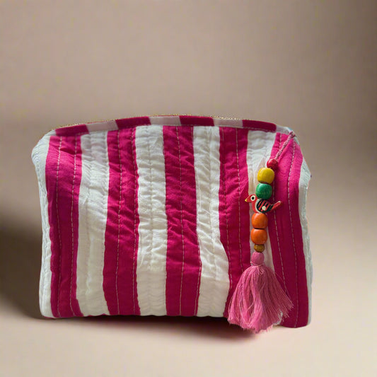 Striped pouch with colorful beads and tassel on a textured surface