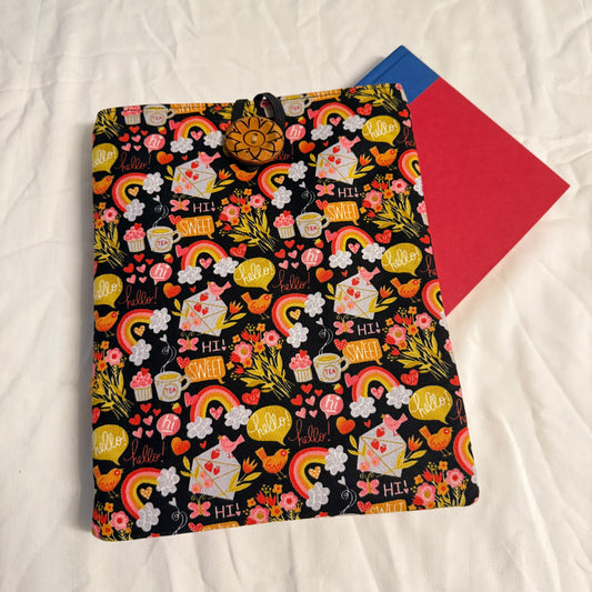Floral and rainbow patterned pouch on a white surface with a red envelope underneath