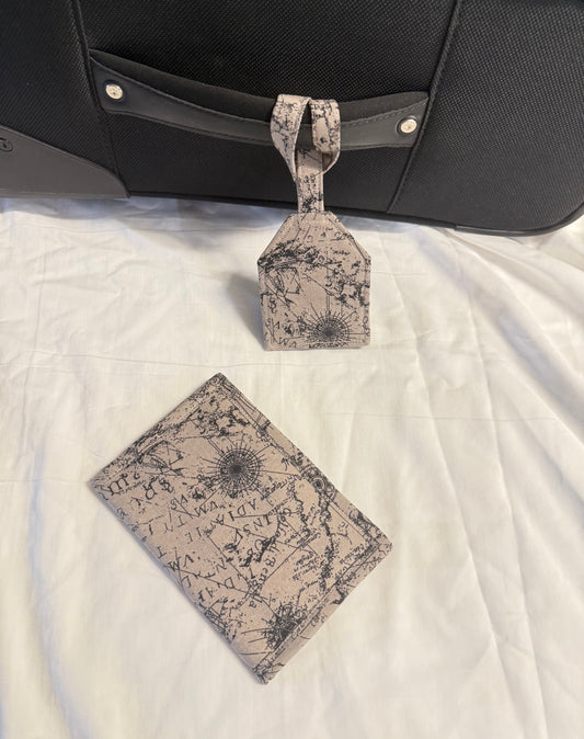 Map-patterned luggage tag and wallet on a suitcase with a white quilted surface background