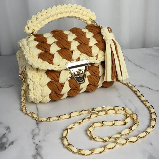 Crocheted handbag with a chain strap on a marble surface