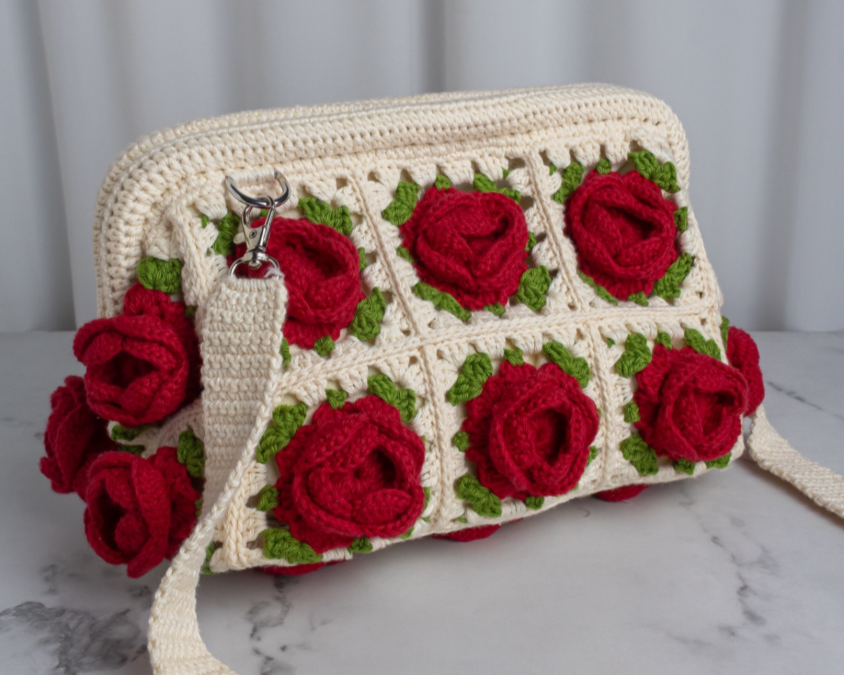 Handmade bag with red rose patterns on a marble surface