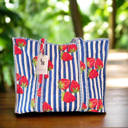 Decorative pillow with strawberry pattern on a blue and white striped background