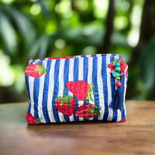 Striped pouch with tomato designs on a wooden surface outdoors